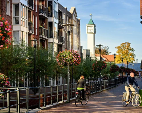 Straatbeeld in Veenendaal met fietsers en een klokkentoren